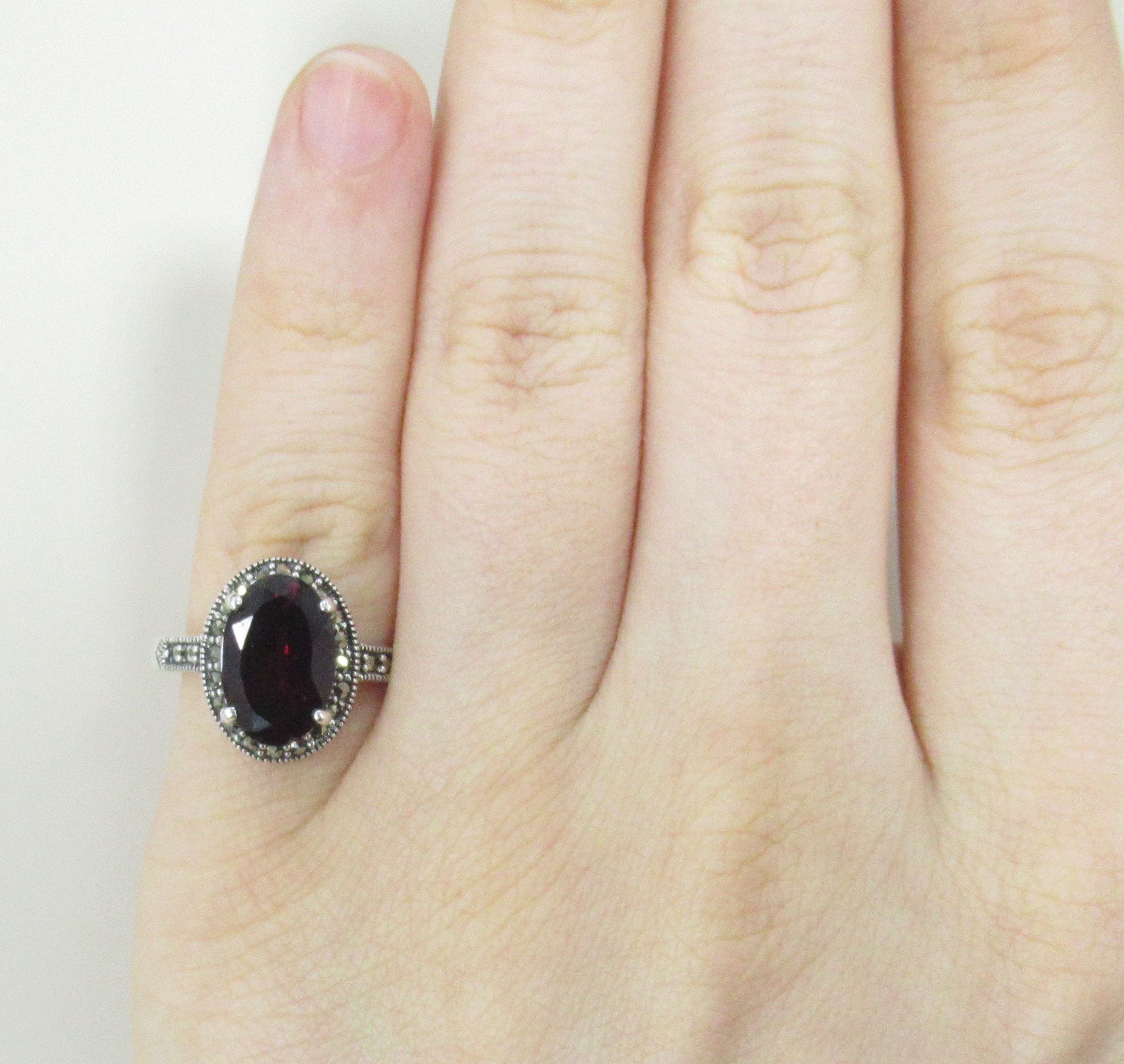 Серебряное кольцо 925 пробы; оксидирование; вставки 1 Гранат; 24 Марказит;